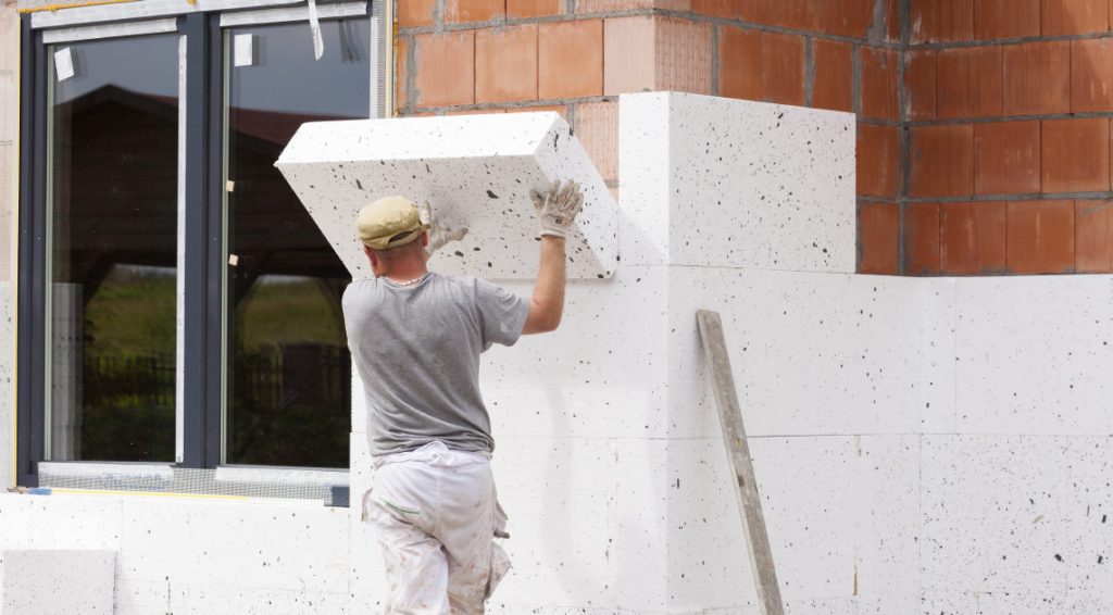 Services Travailleur isolant un mur extérieur.