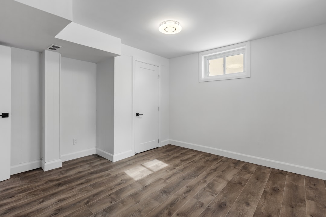 Accueil an-empty-room-with-white-walls-and-wooden-floors-oaclq1shi1k